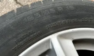 Opona samochodowa z napisem 185/55 R 15. Jest to opona typu radial tubeless, gotowa do montażu.