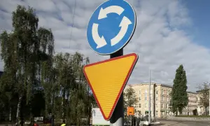 Rondo bez znaku ustąp pierwszeństwa. Znak informuje o ruchu okrężnym, a obok niego znajduje się żółty trójkątny znak ostrzegawczy.