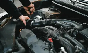 Mechanik dokręca śrubę przy silniku. Może to być związane z uszkodzonym przekaźnikiem pompy paliwa objawy, które utrudniają rozruch auta.