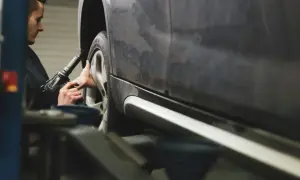 Mechanik dokręca śruby koła kluczem pneumatycznym, dbając o prawidłową zbieżność dodatnią.