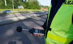 Policjant mierzy poziom hałasu emitowanego przez auto. Sprawdza, ile dB może mieć auto, by nie przekraczać norm.