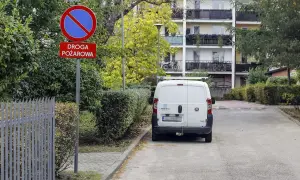 Znak "zakaz zatrzymywania się" i "droga pożarowa" ostrzega przed konsekwencjami, jaki mandat za parkowanie na zakazie grozi kierowcy białego vana.