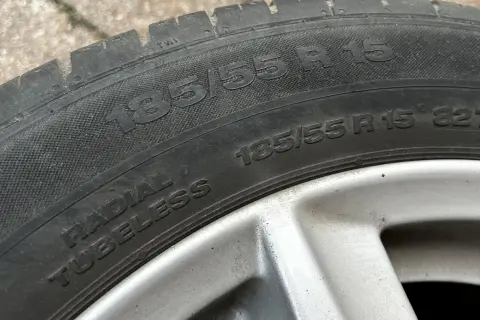 Opona samochodowa z napisem 185/55 R 15. Jest to opona typu radial tubeless, gotowa do montażu.