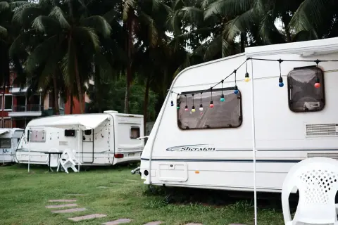 Kemping pod palmami, przyczepy kempingowe z girlandami światełek. Zastanawiasz się, jakie prawo jazdy na przyczepę kempingową?