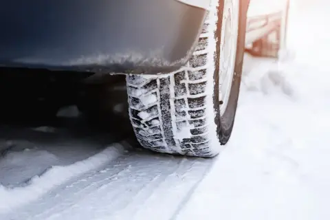 Zimowe opony na śniegu. Czas pomyśleć, kiedy zmienić opony zimowe na letnie, gdy śnieg zaczyna topnieć.