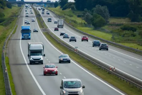 Ruch na autostradzie, gdzie samochody jadą różnymi pasami. Pytanie, czy na autostradzie można wyprzedzać z prawej strony, pozostaje otwarte.