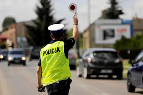 Policjant kieruje ruchem, zatrzymując pojazdy. Może to być kontrola prędkości lub jazda bez rejestracji.