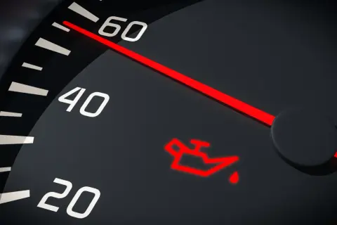 Czerwona kontrolka niskie ciśnienie oleju na desce rozdzielczej. Wskaźnik pokazuje niski poziom.