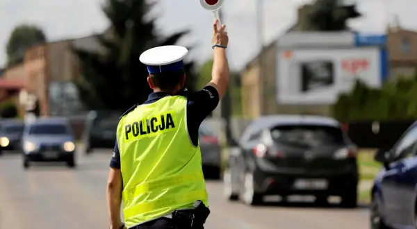 Policjant kieruje ruchem, zatrzymując pojazdy. Może to być kontrola prędkości lub jazda bez rejestracji.