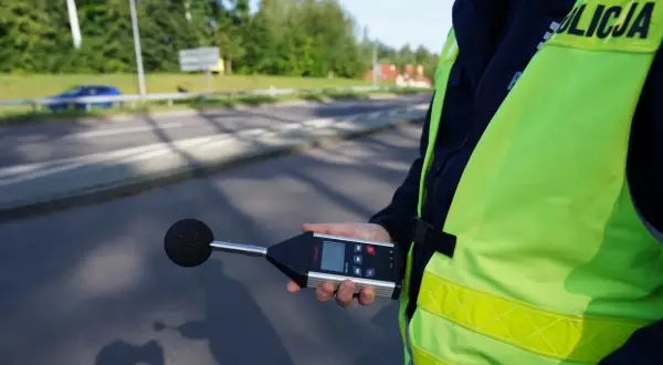 Policjant mierzy poziom hałasu emitowanego przez auto. Sprawdza, ile dB może mieć auto, by nie przekraczać norm.
