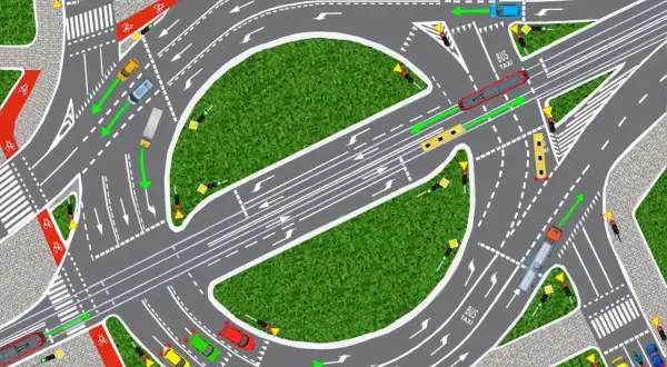 Intensywny ruch na rondzie: samochody, autobus, ciężarówka i taksówki poruszają się po wielopasmowym skrzyżowaniu z sygnalizacją świetlną i ścieżkami rowerowymi.