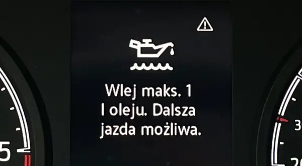 Kontrolka z symbolem oleju i komunikatem "Wlej maks. 1 l oleju. Dalsza jazda możliwa." ostrzega przed niskim poziomem oleju w silniku.