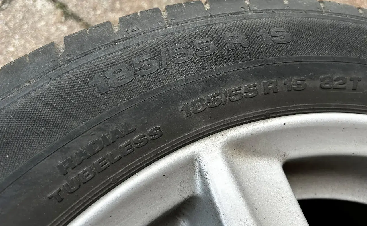 Opona samochodowa z napisem 185/55 R 15. Jest to opona typu radial tubeless, gotowa do montażu.
