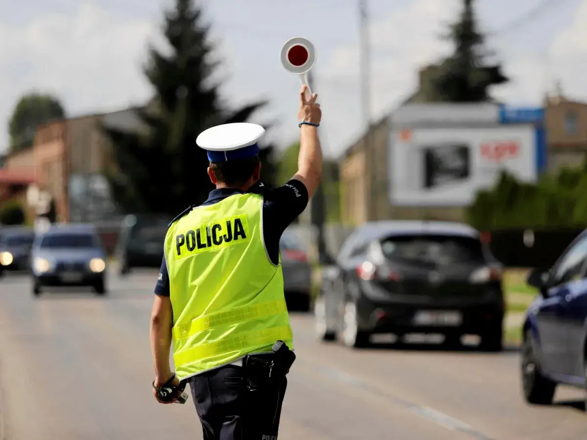 Policjant kieruje ruchem, zatrzymując pojazdy. Może to być kontrola prędkości lub jazda bez rejestracji.