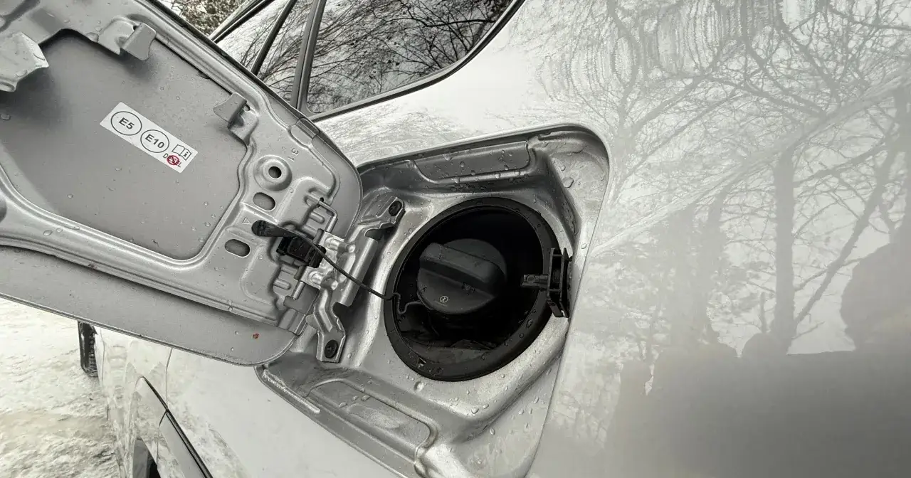 Otwarta klapka wlewu paliwa, widoczne oznaczenia E5, E10, Diesel. Awaryjne otwieranie wlewu paliwa może być konieczne w zimowych warunkach.