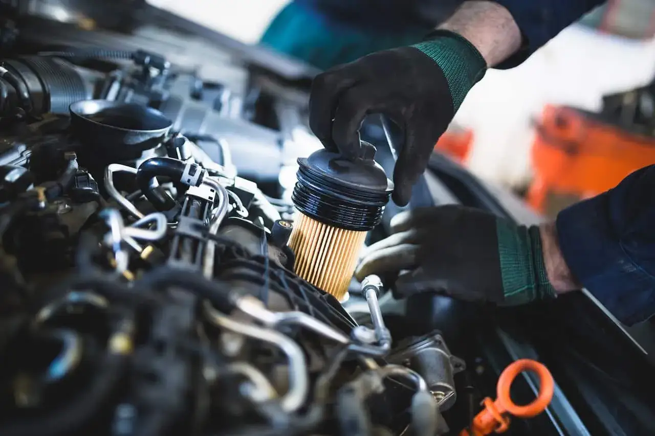 Mechanik wymienia filtr paliwa w silniku. Pamiętaj, co ile wymieniać filtr paliwa, by auto działało sprawnie.