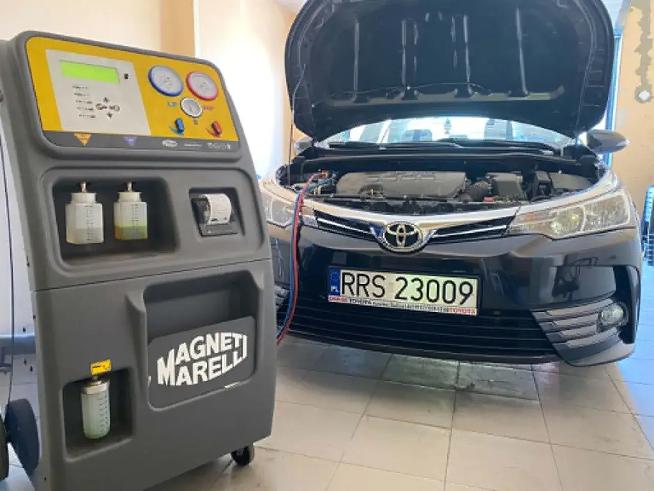Stacja do obsługi klimatyzacji samochodowej Magneti Marelli obok Toyoty. Dowiedz się, ile trwa nabijanie klimatyzacji.