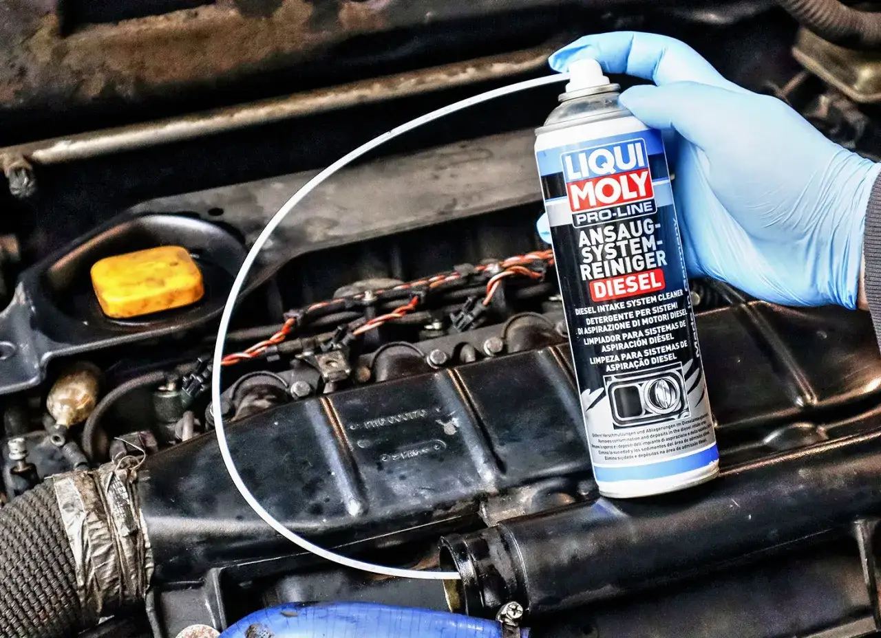 Ręka w niebieskiej rękawiczce trzyma puszkę preparatu Liqui Moly do czyszczenia układu dolotowego diesla. To rozwiązanie, czym wyczyścić EGR.