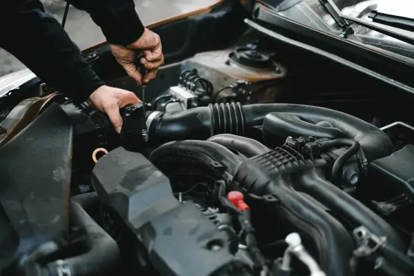 Mechanik dokręca śrubę przy silniku. Może to być związane z uszkodzonym przekaźnikiem pompy paliwa objawy, które utrudniają rozruch auta.