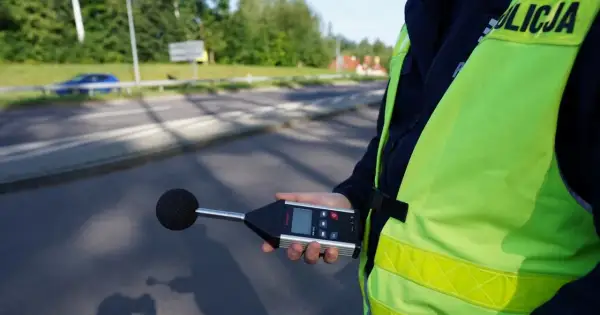 Policjant mierzy poziom hałasu emitowanego przez auto. Sprawdza, ile dB może mieć auto, by nie przekraczać norm.